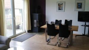 a table and chairs in a living room with a television at Perdöhl-Wittenburg in Wittenburg