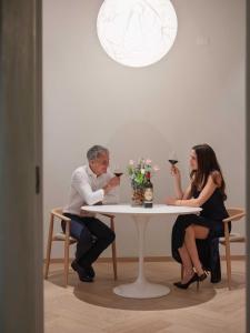 a man and woman sitting at a table with wine glasses at PALAZZO CIOPETA - Italian Excellence in Verona