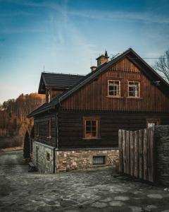a wooden house with a fence in front of it at Jaworowa Osada in Brenna