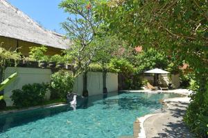 a swimming pool in the backyard of a house at Villa Layangan - Two Bedrooms with Pool Access in Sanur