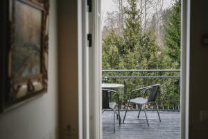 a door leading to a balcony with a table and chairs at Ööbikuoru Villa in Rõuge