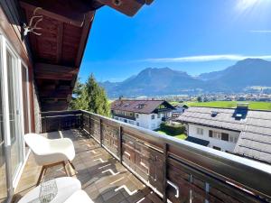 a balcony with a white chair and a view of mountains at Ferienhaus Alpenlodge in Oberstdorf