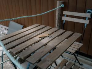 a wooden bench with a pair of scissors on it at Banyula Cove by Tiny Away in Barnes Bay