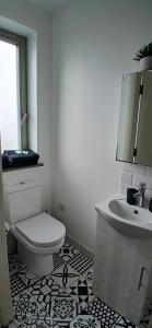 a white bathroom with a toilet and a sink at Cozy Double Ensuite Room in Ennistymon