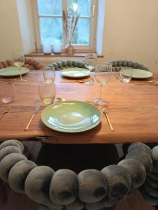 a wooden table with plates and wine glasses on it at Zeitinsel Doos in Waischenfeld