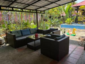 a patio with couches and a table and flowers at Coconut Village Guesthouse and Bungalow in Kep