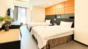 a hotel room with two beds in a room at San Juan Easy Stay Inn Tainan in Tainan +27 photos