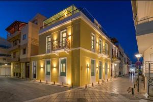 a yellow building on a street at night at Artion City Boutique Hotel in Heraklio