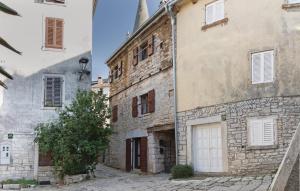 an old stone building with a white door and a tree at Marija's House in Bale