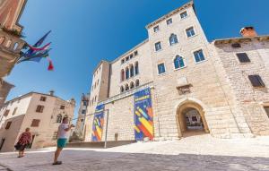a man flying a kite in front of a building at Marija's House in Bale +6 photos