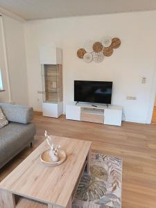 a living room with a tv and a coffee table at Zeitinsel Doos in Waischenfeld