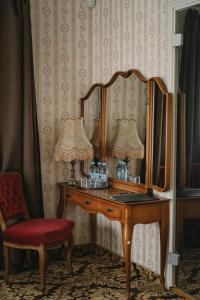 a dressing table with a mirror and a red chair at Ööbikuoru Villa in Rõuge +41 photos