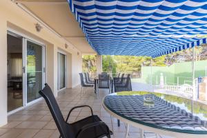 a patio with a table and chairs under a blue ceiling at Villa Carousel in Benidorm