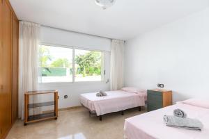 a bedroom with two beds and a window at Villa Carousel in Benidorm +37 photos
