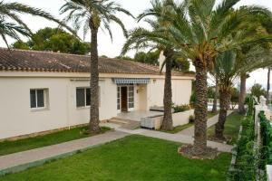 a house with palm trees in the yard at Villa Carousel in Benidorm