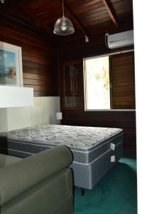 1 dormitorio con 1 cama y 1 sofá en Casa De Madeira, en Bombinhas