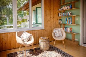 two chairs sitting in a room with a book shelf at Villa Marienhof in Annenheim