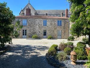 an old stone house with a garden in front of it at Le Durivum in Montaigu-Vendée