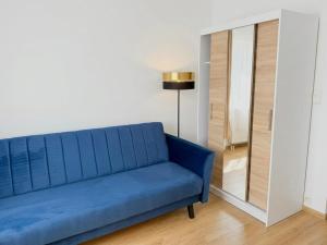 a blue couch in a living room with a lamp at Astral in Raszyn