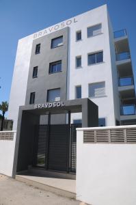 a white building with a sign on the front of it at Apartamentos Bravosol in Denia