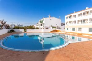 a large swimming pool in front of a building at Apartamento en Cala'n Blanes in Ciutadella
