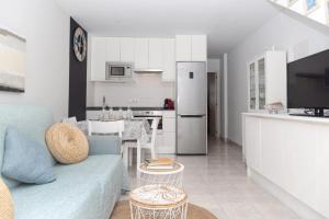 a living room with a blue couch and a kitchen at Apartamento en Cala'n Blanes in Ciutadella