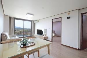 a living room with a table and a television at Ilsung Resort Sulak in Goseong