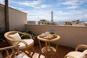 a table and chairs on a balcony with a lighthouse at Seafront Iconic Lighthouse View Punta Secca in Punta Secca