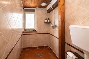 a bathroom with a shower with a toilet and a window at Seafront Iconic Lighthouse View Punta Secca in Punta Secca