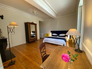 a bedroom with a bed and a table with a flower on it at Le Durivum in Montaigu-Vendée +47 photos