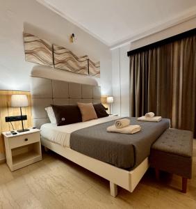 a bedroom with a large bed with two towels on it at Summerscape Studios and Apartments in Corfu