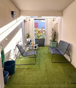 a patio with chairs and a table and grass at Blue Harmony in Massy