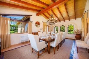 a dining room with a wooden table and white chairs at Villa Privada De Lujo Con Spa in Inca