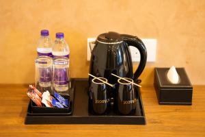 a black coffee pot with a pair at Ascot Hotel in Kozhikode