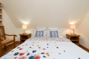 a bedroom with a bed with a floral bedspread and two lamps at Le Moulin De Lesnevé in Saint-Avé +49 photos