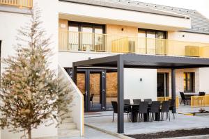 a house with a balcony and a table and chairs at KQC Boutique Villa in Balatonlelle