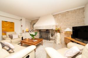 a living room with white furniture and a fireplace at Le Moulin De Lesnevé in Saint-Avé