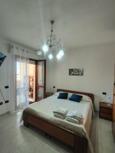 a bedroom with a large bed and a chandelier at "Da Carla e Sandro"- Appartamento con parcheggio privato in Quartucciu +58 photos