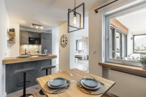 a kitchen and dining room with a wooden table at Rosels Mountain Lodge - Ferienwohnung mit Schwimmbad, Sauna & Bergblick - Oberaudorf Bayern in Oberaudorf