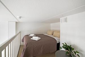 a bedroom with a bed with towels on it at Sonetti - Metso library apartments Come in! in Tampere