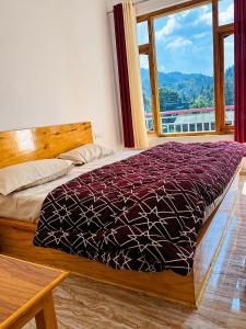 a bedroom with a bed and a large window at Barot Palace in Barot 