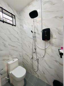 a bathroom with a toilet and a shower in it at UZ Jerteh Inn in Jertih +10 photos