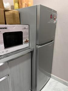 a refrigerator with a microwave on top of it at UZ Jerteh Inn in Jertih