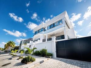 a white house with a black fence and palm trees at Easyhome in Brazzaville