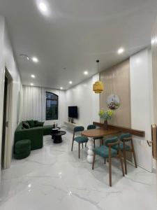 a living room with a green couch and a table at Sunrise Apartments in Xóm Niêm