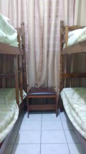 a room with two bunk beds and a chair at Mares do Sul Apartment in Praia Grande