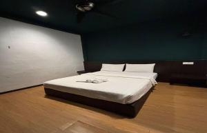 a bed in a room with a green wall at Room V Jalan Jenang by SECOMS in Batu Pahat