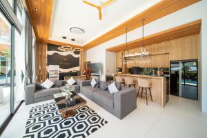 a living room with a couch and a table at Mouana Breeze Mai Khao VIP 4-bedroom Pool Villa 9911 in Phuket