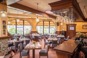 a restaurant with tables and chairs and windows at Hotel Ognisty Ptak in Węgorzewo