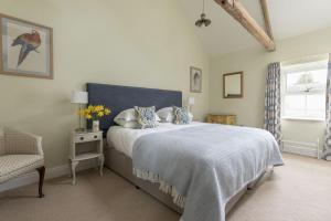 a bedroom with a bed and a chair and a window at The Hat Shop in Hexham